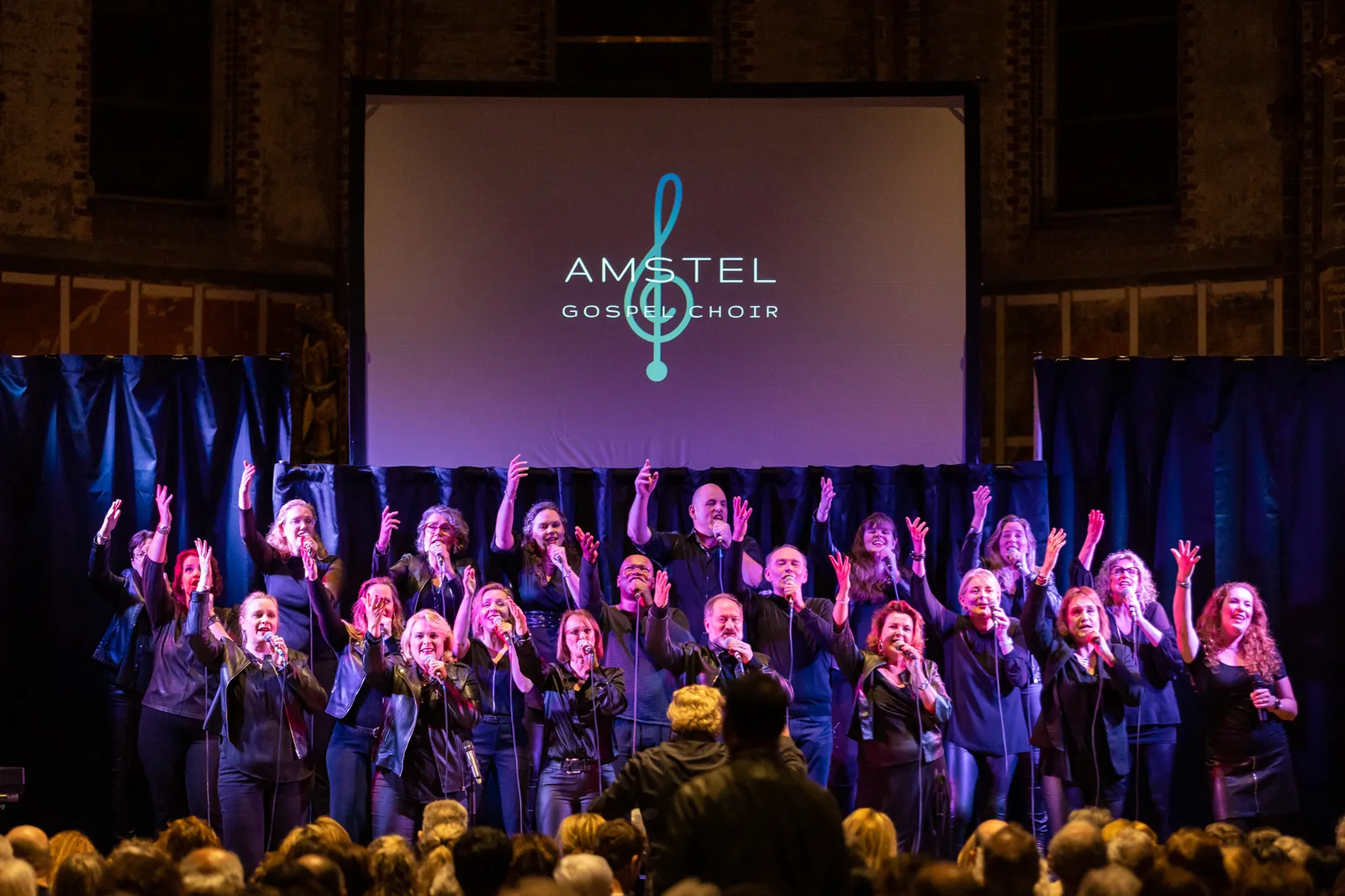 Koor zingt met handen omhoog